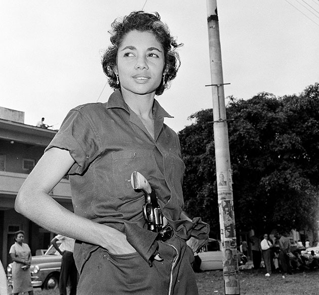 A young unidentified woman patrols near a headquarters building in Havana, Jan. 4, 1959.