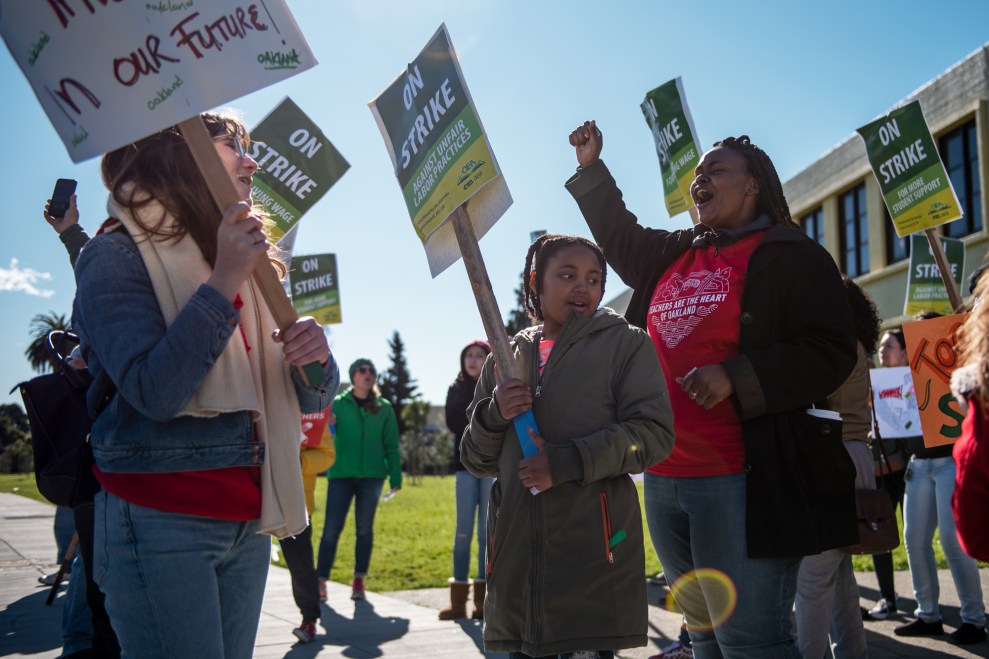 Magdaline Armstrong (right), a first grade teacher, and her daughter Nilaya, 8, rally on a picket line with kindergarten teacher Grace Allen (left) outside Lockwood Elementary School in Oakland, Calif., on February 21, 2019.