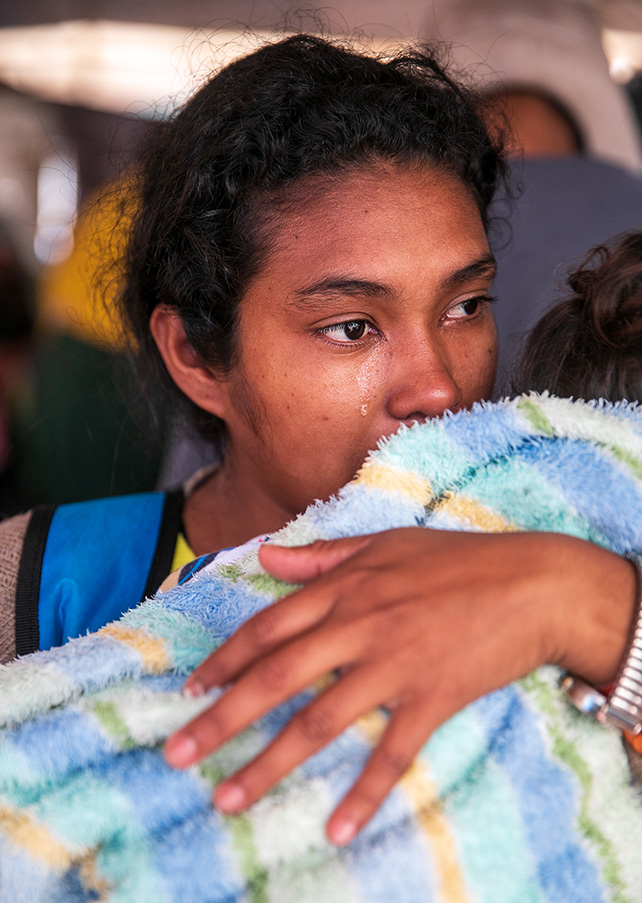 Arlen Cruz 22, wipes away a tear while holding her two year-old daughter in Tijuana, Mexico, on November 29, 2018.