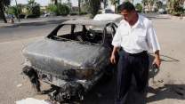 A policeman examines a car attacked by the Blackwater guards.