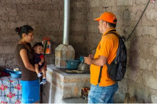 A project supervisor is seen here conducting a follow-up visit and speaking with local residents who have received a clean cookstove as a result of the initiative in Honduras.
