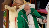 Pope Francis sitting, rubbing his eyes.