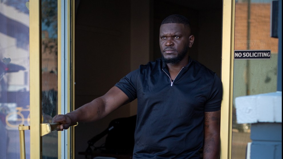 Man standing in doorway, holding open door.