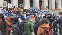 New York City Council member Erik Bottcher is speaking to the crowd outside the James A. Farley Building in Manhattan during a American Postal Workers Union protest.