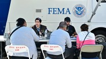 FEMA staffers sit in front of a branded truck.