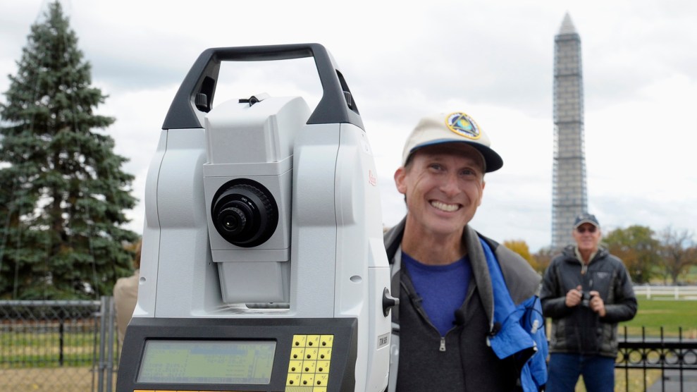 A man smiles next to a large white, black, and yellow device.
