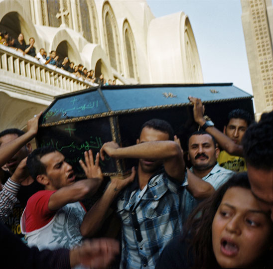 Relatives of victims carry coffins out of the Abbasiya Cathedral to be buried following violence that took place in front of the Maspero TV building on October 9 and 10, 2011. The clashes, which resulted in 28 deaths and left 212 injured, occurred between Copts demonstrating peacefully against an attack on a church in Upper Egypt and the Egyptian Army and security forces. The Copts were violently dispersed by tanks and armored vehicles, as well as random shooting in the crowd.