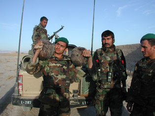 Afghan National Army soldiers display more than six kilograms of opium discovered in a former insurgent safe house in the Farah province of Afghanistan Dec. 16, 2007. (Photo courtesy of Combined Joint Special Operations Task Force - Afghanistan) 